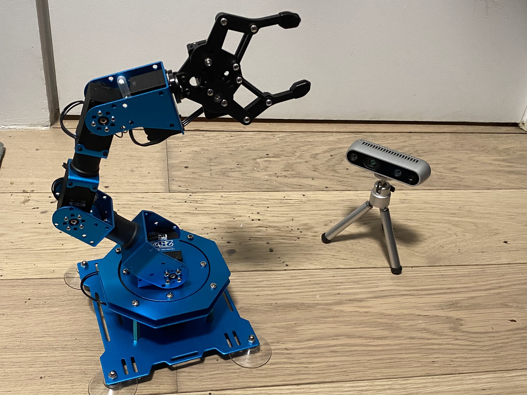The robot arm I assembled for telerobotics tasks, alongside a depth camera intended for visual self modeling